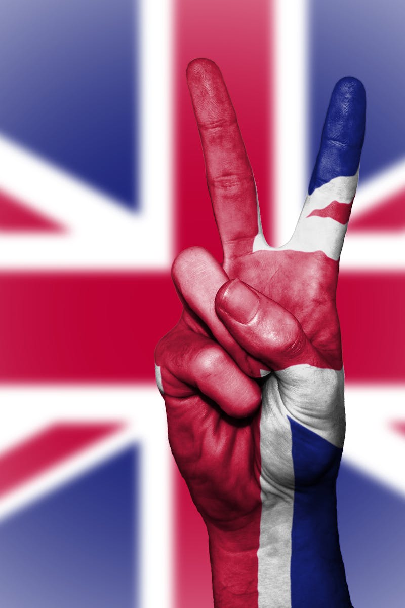 Illustration of a hand showing a peace sign with the UK flag background.