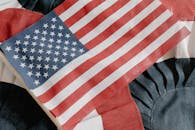 Close-up of the American flag on a textured fabric backdrop, symbolizing patriotism and national pride.